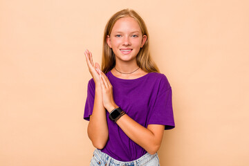 Caucasian teen girl isolated on beige background feeling energetic and comfortable, rubbing hands confident.