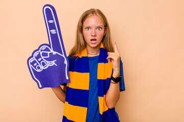 Little caucasian sports fan girl isolated on beige background having some great idea, concept of creativity.