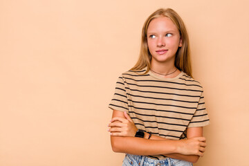 Obraz premium Caucasian teen girl isolated on beige background smiling confident with crossed arms.