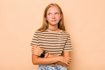 Caucasian teen girl isolated on beige background dreaming of achieving goals and purposes