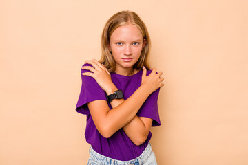 Caucasian teen girl isolated on beige background hugs, smiling carefree and happy.