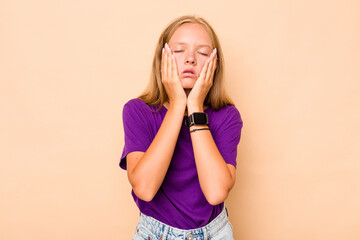 Caucasian teen girl isolated on beige background whining and crying disconsolately.
