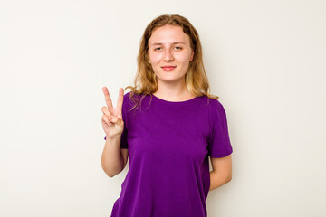 Young caucasian woman isolated on white background showing victory sign and smiling broadly.