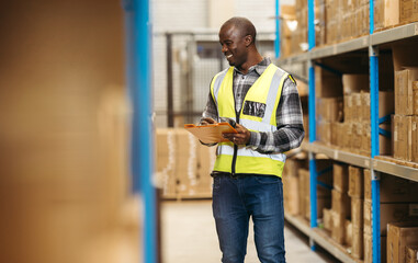 Happy warehouse manager taking stock using a barcode scanner in a logistics centre