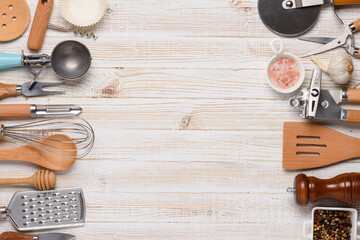 Various kitchen utensils on white wooden table top view with copy-space