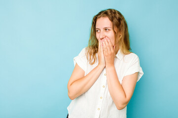 Young caucasian woman isolated on blue background laughing about something, covering mouth with hands.