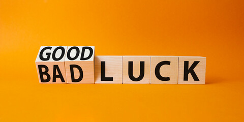 Good Luck and bad Luck symbol. Turned wooden cubes with words Bad Luck and Good Luck. Beautiful orange background. Business concept. Copy space