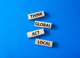 Think global act local symbol. Wooden blocks with words Think global act local. Beautiful blue background. Business and Think global act local concept. Copy space.