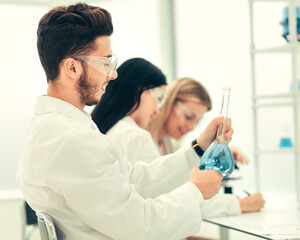 Obraz na płótnie Canvas group of scientists examines the liquid in the laboratory