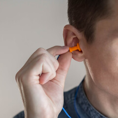 Man putting earplugs into ear