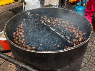 Malaysia, July 10, 2022 - Chestnuts being roasted outdoors at market.