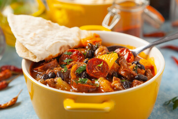 Pork stew with chorizo and black beans. Served with orange and seasoned with hot chili peppers. Perfect with tortillas.