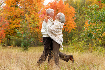 Elderly couple dance in autumn. Full length 