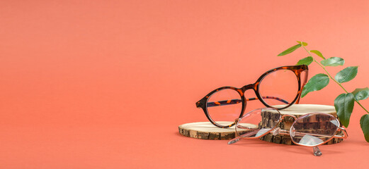 Stylish round eyeglasses on a wooden podium. Glasses sale banner