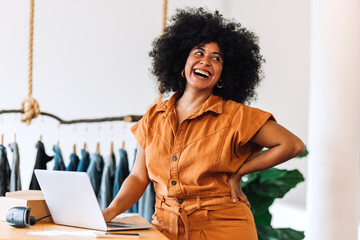 Female small business owner smiling happily in her online clothing store