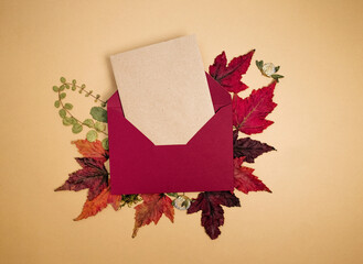Red envelope and autumn leaves on background