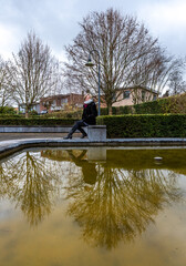 Obraz premium Model posing at a water pond with her profile reflecting in the water