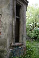 Old, dilapidated palace with roofed windows in wild green surroundings