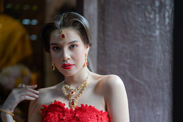 Beautiful portrait pretty woman red dressed as an Indian sexy girl with red lips. Young Hindu...