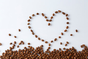 coffee beans scattered in the shape of a heart on a white background