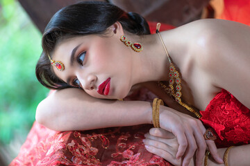 Beautiful portrait pretty woman red dressed as an Indian sexy girl with red lips. Young Hindu...