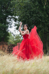 Beautiful portrait pretty woman red dressed as an Indian sexy girl with red lips. Young Hindu Pakistani Bride and glamour makeup in a fashion jewelry set.