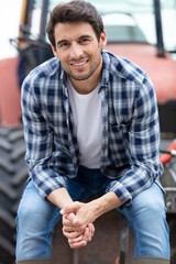 portrait of a farmer sitting on a tractor smiling
