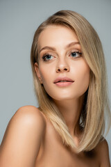Fototapeta premium portrait of pretty blonde woman with blue eyes and natural makeup isolated on grey.