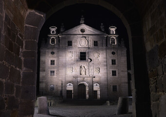 Santa Teresa church view through gate of the walls at night in Avila, Spain