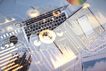 Technology hologram drawing over computer on the desktop background. Top view. Double exposure. Tech concept.