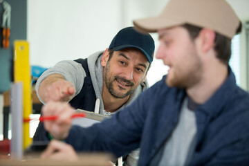 man in factory pointing to attract colleagues attention