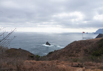 Beautiful Teluk Bay with blue ocean, clouds, and mountains in Jember, East Java, Indonesia.