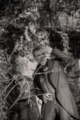 Vampire man wearing victorian suit is afraid of the sun's rays. Vintage medieval concept style. Black and white photo.