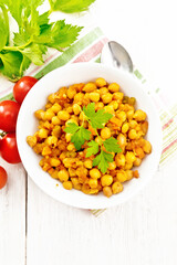 Chickpeas stewed with vegetables in plate on light board top