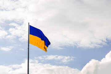Ukrainian flag blowing on a wind bright sky background simple wallpaper advertising copy space concept