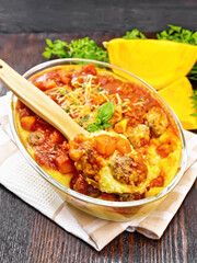 Porridge corn with meat and spoon in roaster on table
