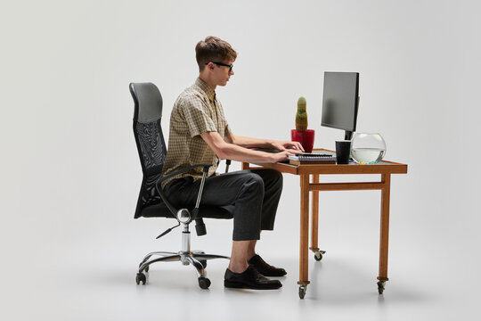 Young programmer. Portrait of smart and serious student sitting at computer desk and studying. Studying, education, youth, remote workplace concept