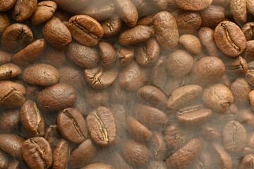 The texture of freshly roasted, ready-to-drink coffee, steam rising above the beans, black ava beans.