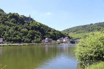 Fototapeta na wymiar The town of Traben-Trarbach on the bank of the Moselle river with an medieval castle ruin on the top of the hill above the town