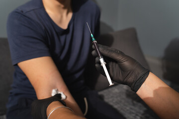 A close up of hands and blood draw process