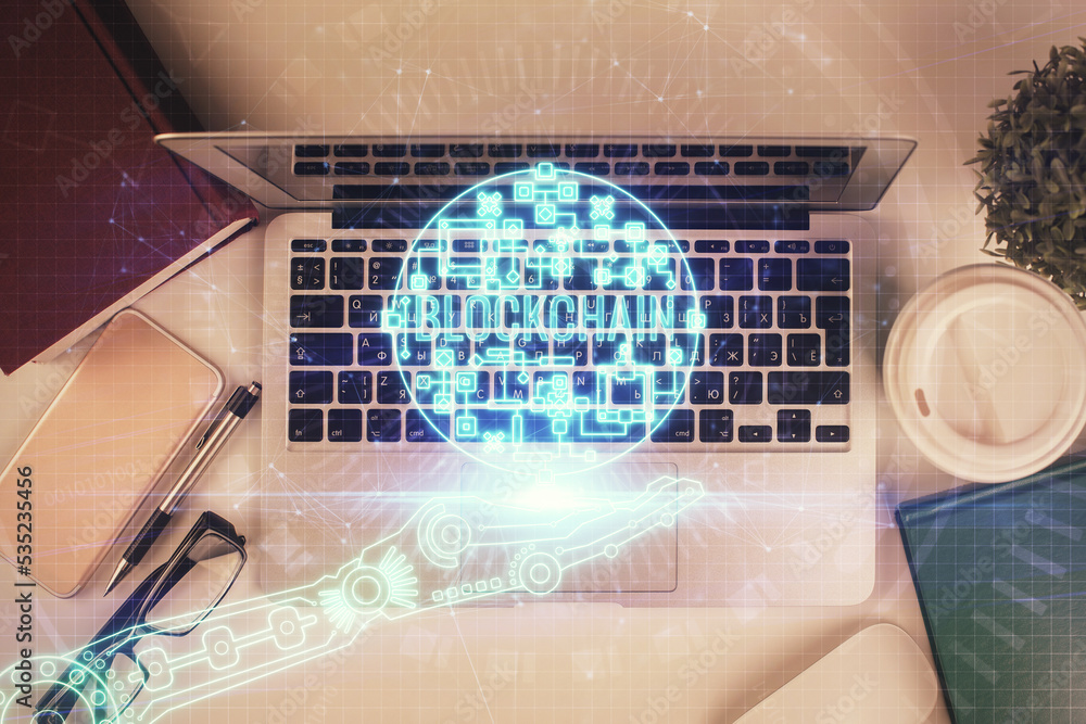 Poster Blockchain theme hologram drawings over computer on the desktop background. Top view. Double exposure.