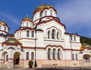 Fototapeta na wymiar New Athos, Abkhazia - October 17, 2021. The New Athos Monastery with bright golden domes on a sunny autumn day.