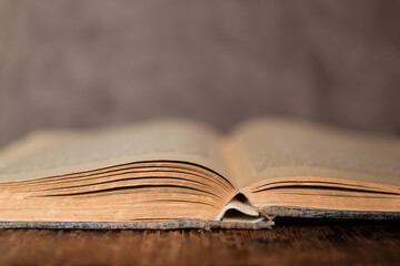 old book on wooden surface. background of a stack of a bible on an open library.