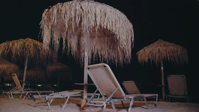 Beach with sunbeds and umbrellas at night, Moraitika beach