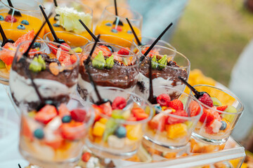 Fruit salad with berries in a glass bowl with a spoon