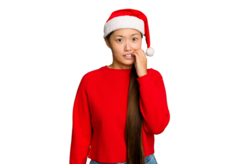Young asian woman celebrating Christmas isolated on green chroma background biting fingernails, nervous and very anxious.