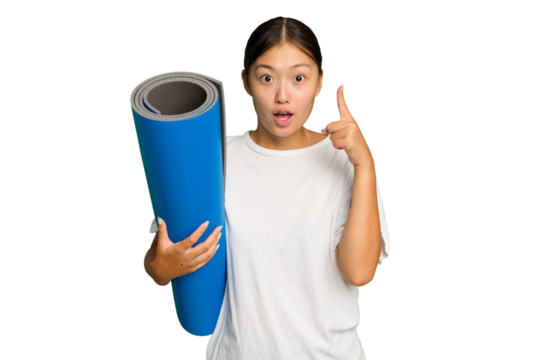 Young asian woman holding a mat isolated on green chroma background having an idea, inspiration concept.