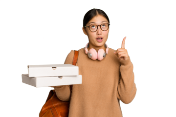 Young student Asian woman holding pizzas isolated on green chrome background pointing upside with opened mouth.