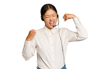 Telemarketer asian woman working with a headset isolated on green chroma background raising fist after a victory, winner concept.