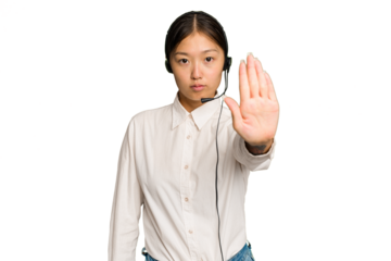 Telemarketer asian woman working with a headset isolated on green chroma background standing with outstretched hand showing stop sign, preventing you.